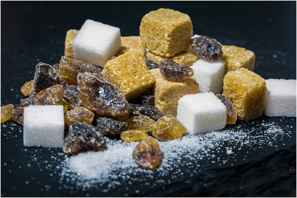 Assorted types of sugar in various textures and colors displayed in small containers